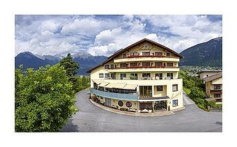 Außenansicht Hotel Arzlerhof mit Bergen und Wolken im Hintergrund