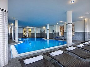 Hotelschwimmbad mit gemütlichen Liegen zum Entspannen.